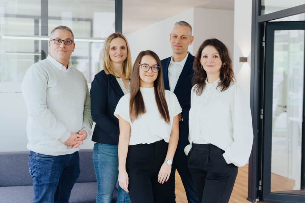 Teamfoto mit den Mitarbeitern von Bergerhoff Immobilien in den Büroräumen